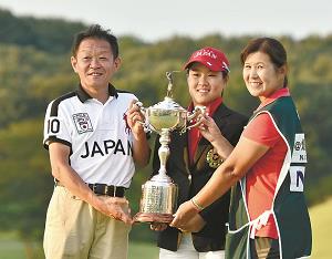 母親の博美さんと父親の仁一さんの3人で優勝杯を手に笑顔を見せる畑岡奈紗選手の写真